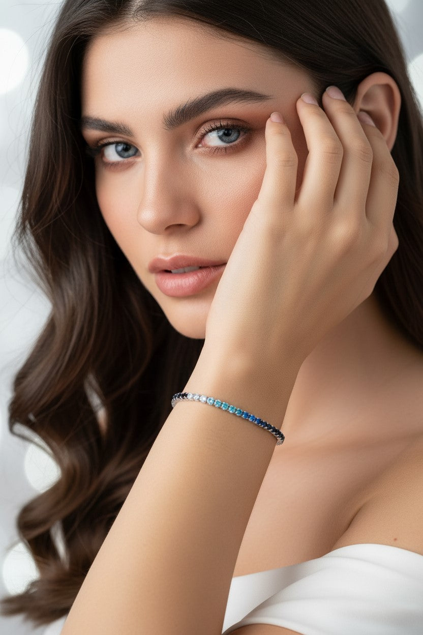 Pulseira tênis prateada com pedras transparentes e coloridas em tons de azul em aço inoxidável. Pode ser combinado com o colar