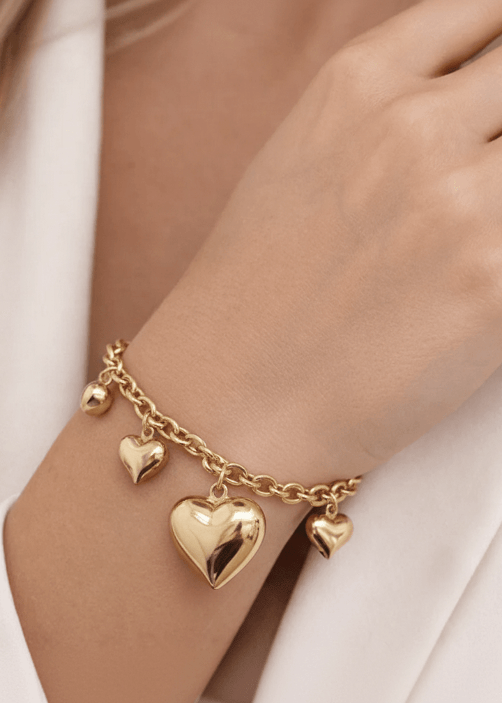 Modella con bracciale dorato a cuori di diverse dimensioni